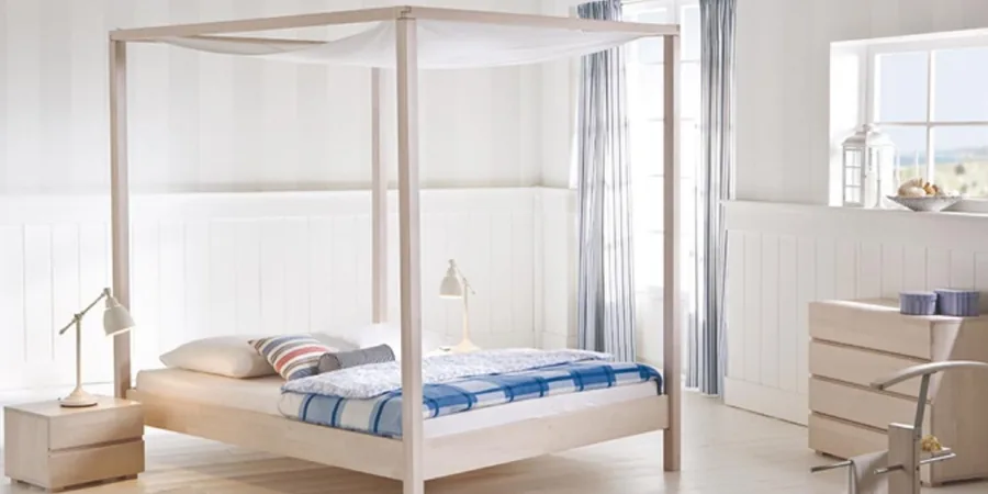 Himmelbett aus hellem Holz mit blau-weiß karierter Bettwäsche und Nachttisch.
